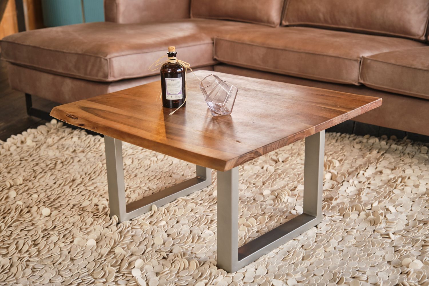 Der KAWOLA Couchtisch LORE ist mit seiner Massivholzplatte ein ganz besonderes Möbelstück. Die Tischplatte aus massivem Akazienholz wurde gebeizt